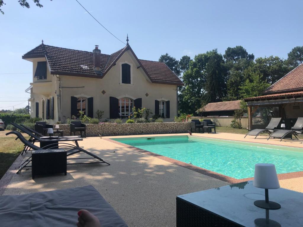 una casa con piscina di fronte a una casa di Chambres d´hotes VILLA CAPSYLVAINE a Captieux