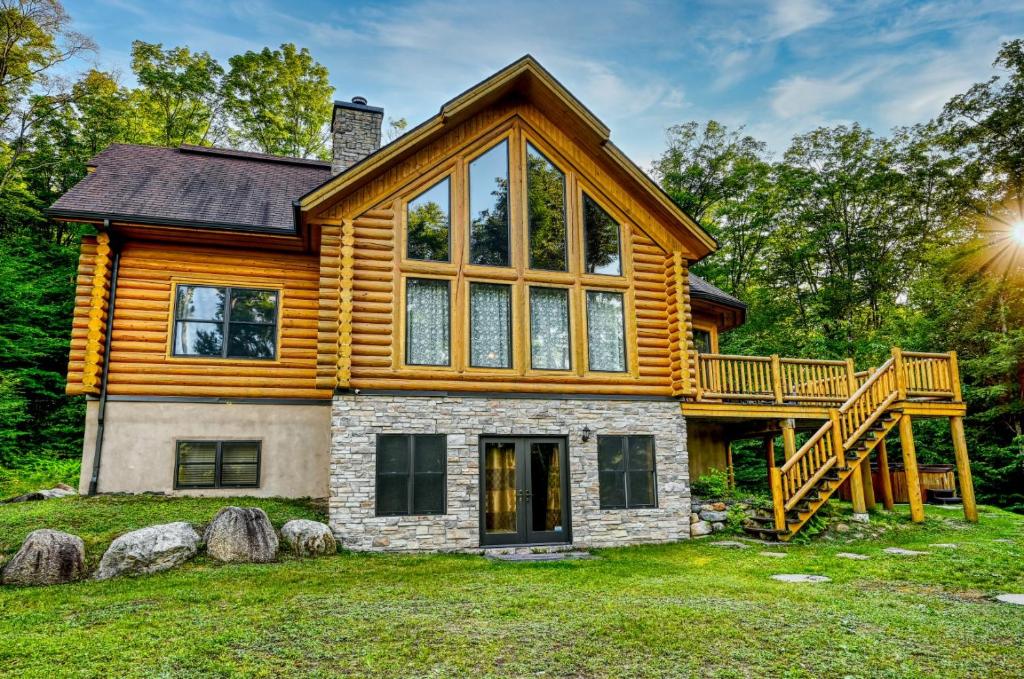 a custom log home with a wrap around deck at Grande Forêt by Tremblant Platinum in Mont-Tremblant