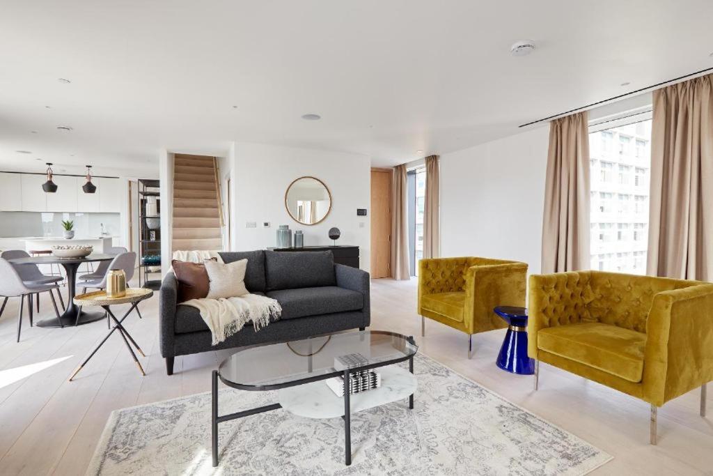 uma sala de estar com um sofá e duas cadeiras em Southwark by Q Apartments em Londres