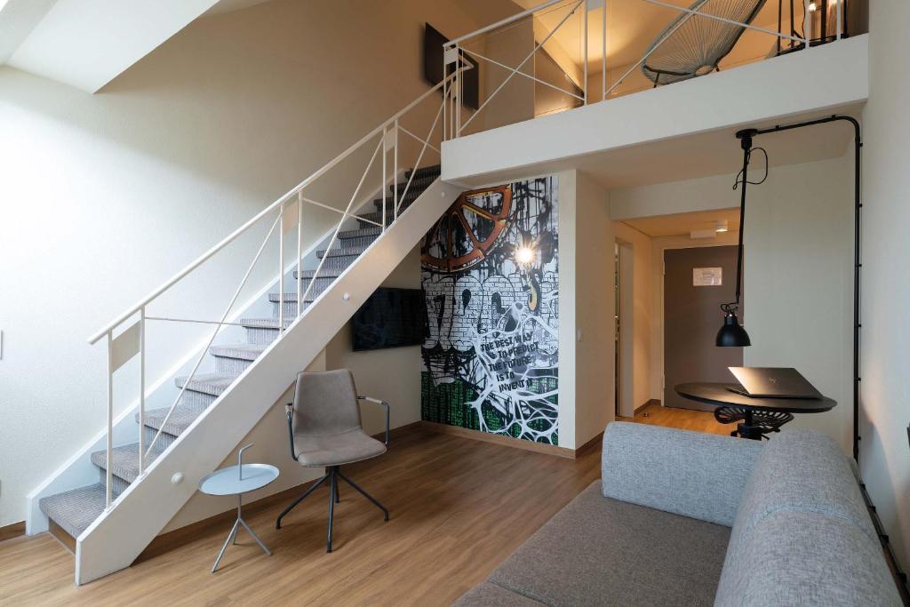 a living room with a staircase and a table at Seminaris Hotel Bad Boll in Bad Boll