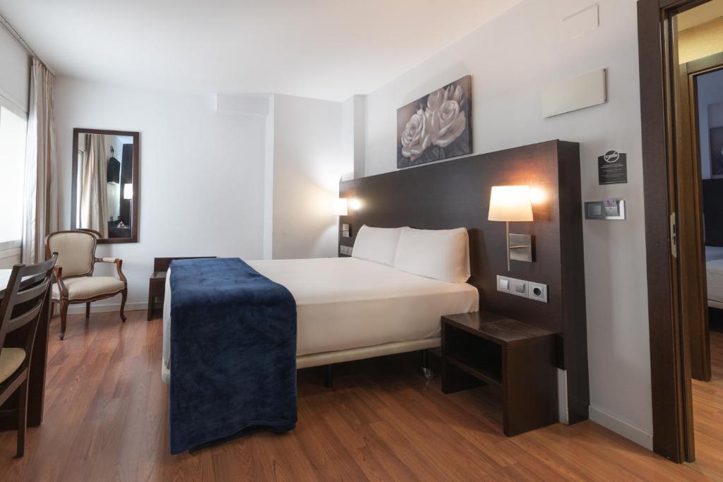 a hotel room with a bed and a desk at Hotel Alda Zaragoza Independencia in Zaragoza
