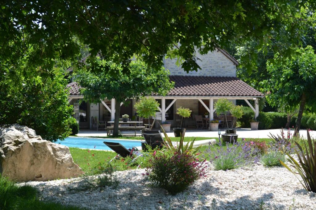 a house with a swimming pool in a yard at Chambre d'hôtes Au Picatal in Meyronne