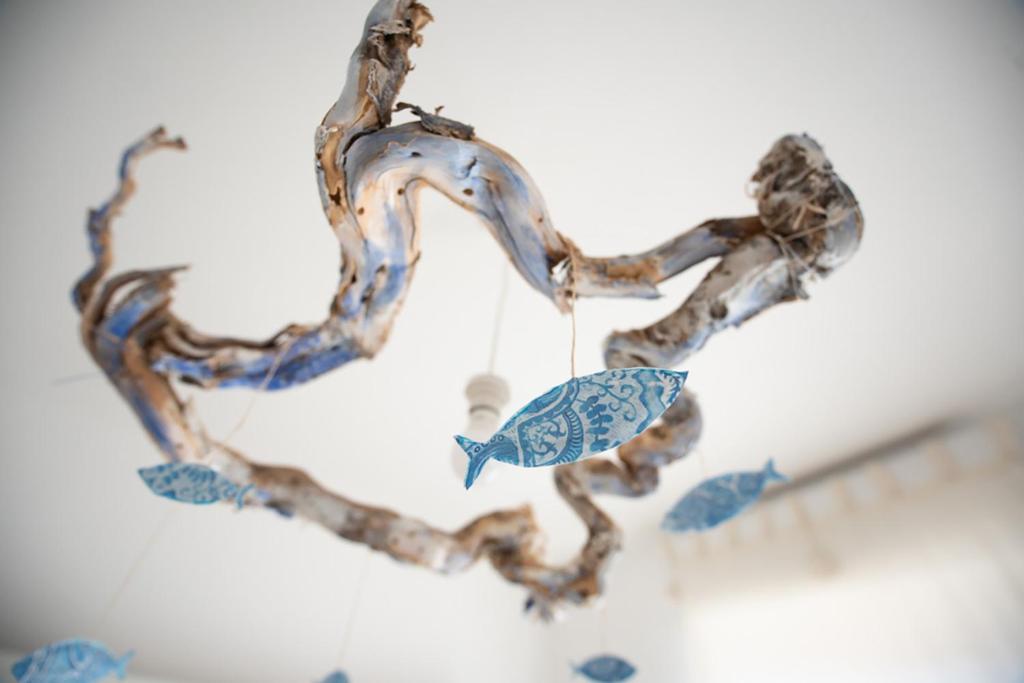 un lampadario di vetro con un uccello su un ramo di Blue Fish Home a Giardini Naxos