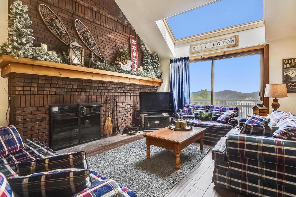 a living room with couches and a fireplace at Sunrise East Glade C8 in Killington