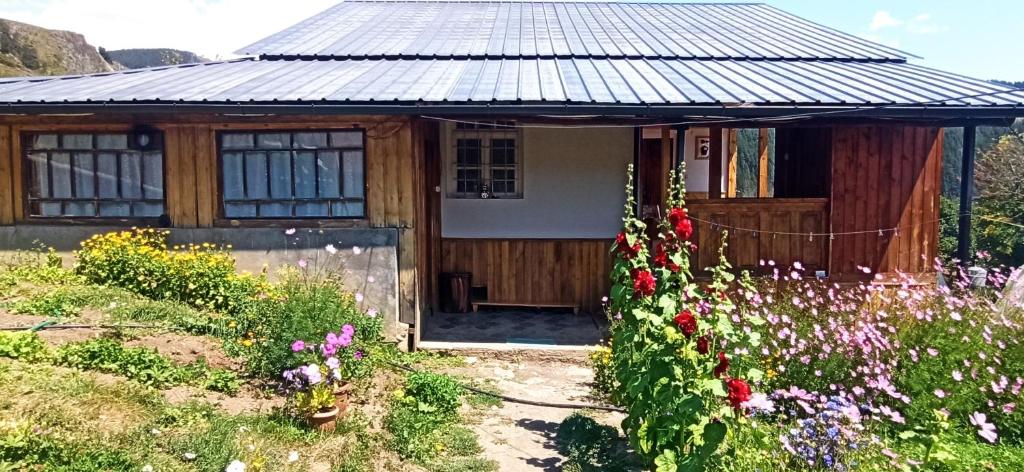 una pequeña casa con flores delante en Guesthouse Sagrila en Omalo