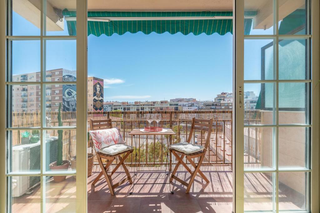 einen Balkon mit einem Tisch und Stühlen sowie Aussicht in der Unterkunft Apartamento de 3 habitaciones en el barrio de las Artes, Soho in Málaga