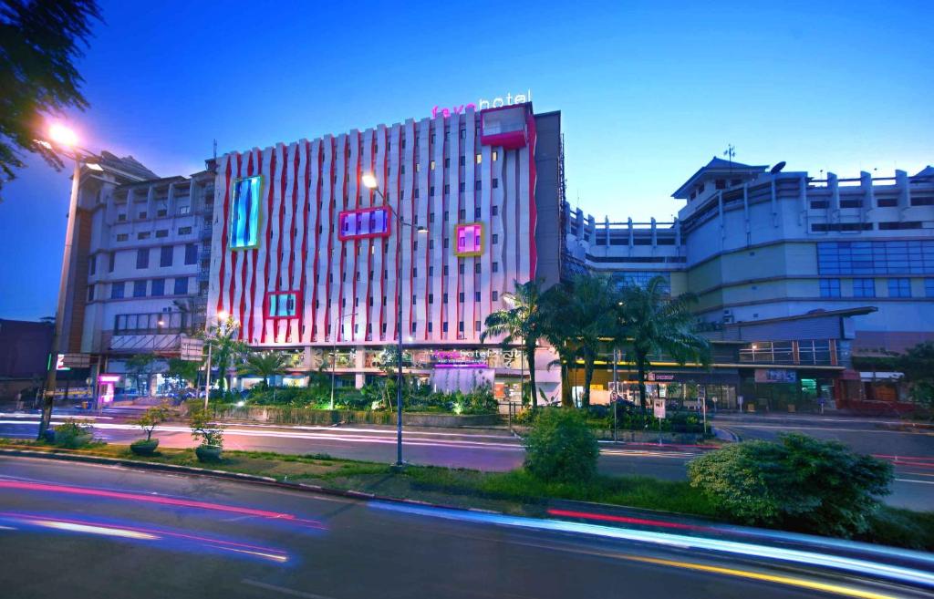 um edifício com luzes vermelhas no lado de uma rua em favehotel PGC Cililitan em Jacarta