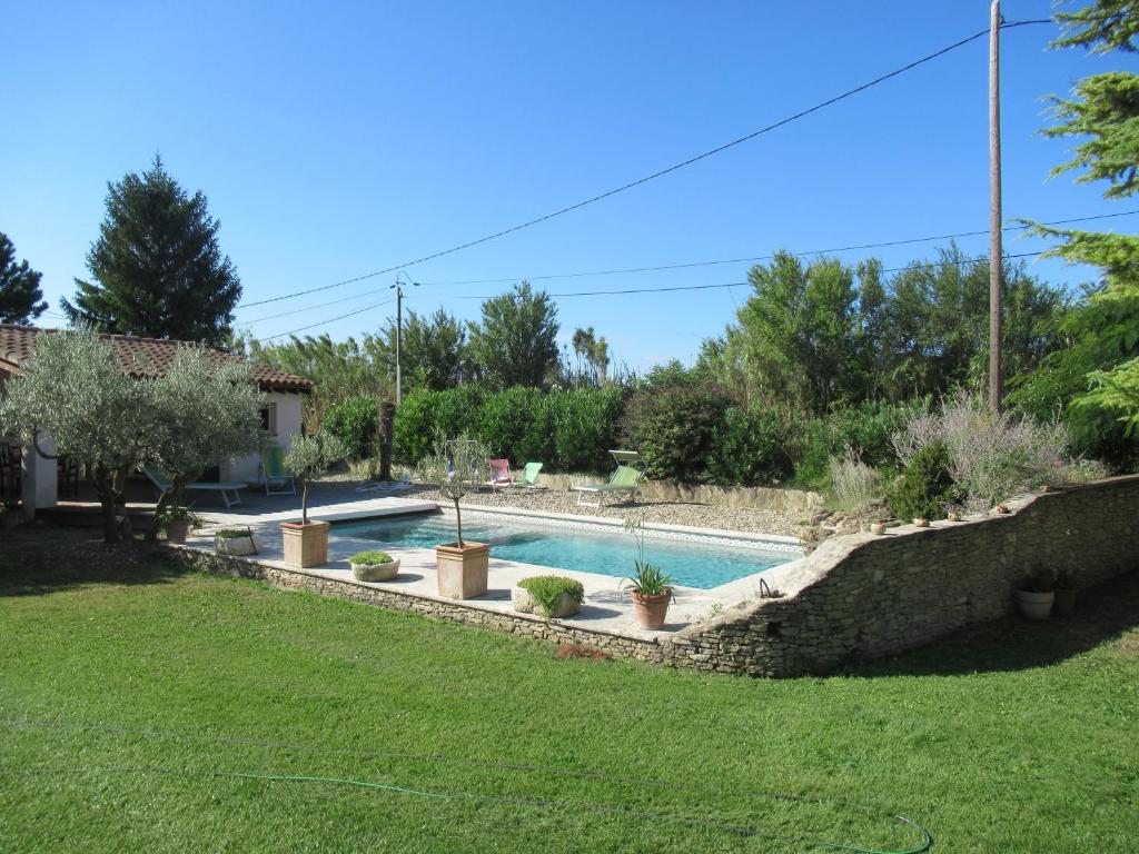 - une piscine avec des plantes dans une cour dans l'établissement LA MASTRONA, à Saumane-de-Vaucluse