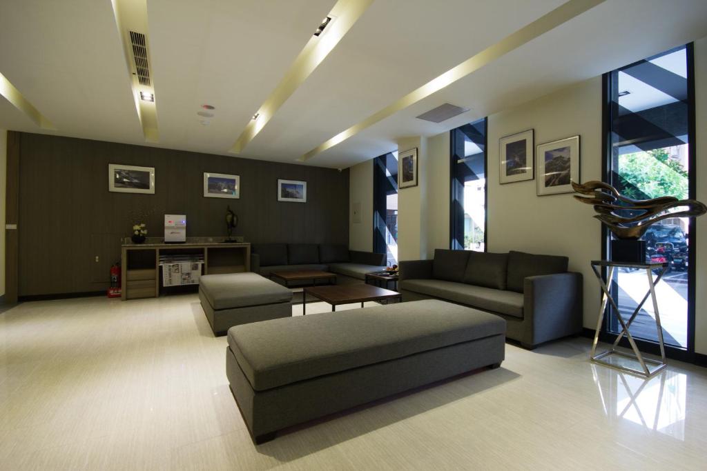 a living room with two couches and a table at Royal Guest Hotel in Tainan