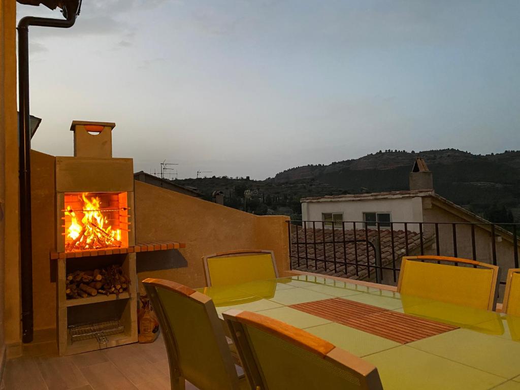 eine Terrasse mit einem Kamin, einem Tisch und Stühlen in der Unterkunft Casa del Caballo in Casas Altas