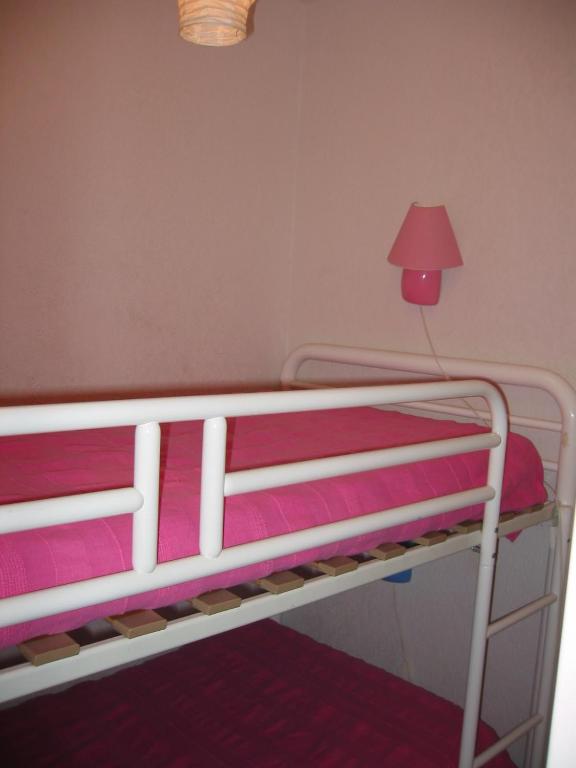 un lit superposé avec des draps roses et une lampe rouge dans l'établissement Apartment With Sea View, à Six-Fours-les-Plages
