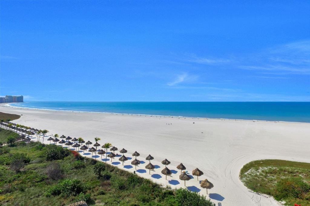an aerial view of a beach with umbrellas and the ocean at Sunny beachfront condo with pool and SW-facing balcony in Marco Island