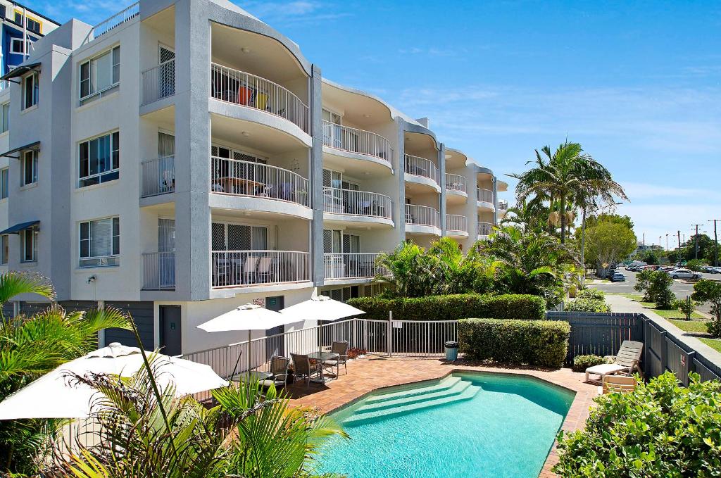 a hotel with a swimming pool in front of a building at The Beach Houses Maroochydore in Maroochydore