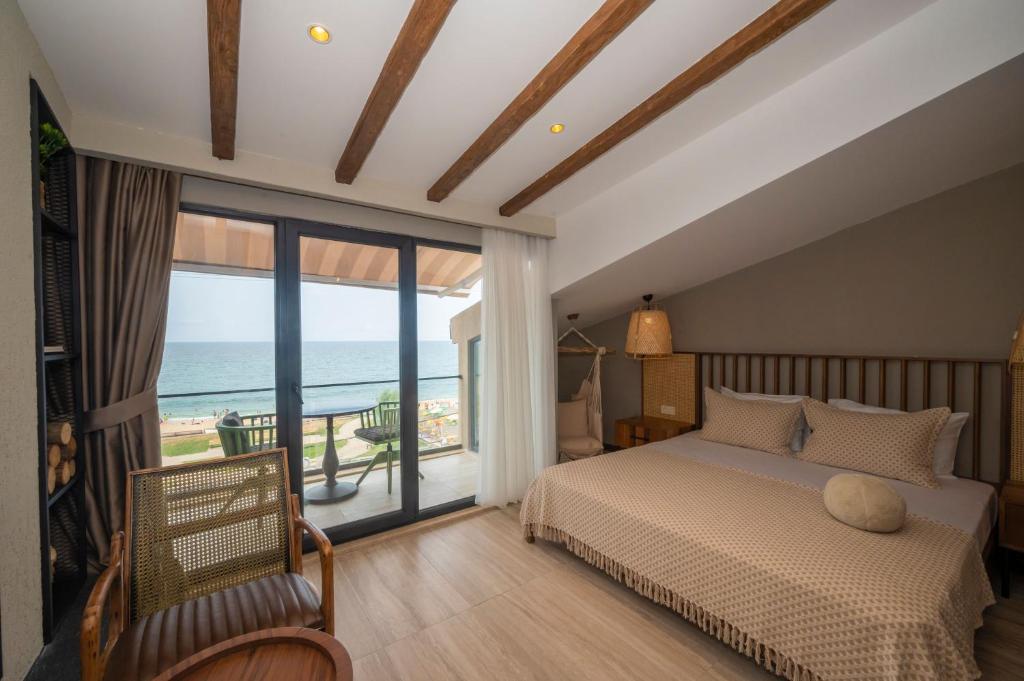 Villa Siesta Hotel Istanbul Airport في Karaburun: غرفة نوم مع سرير وإطلالة على المحيط