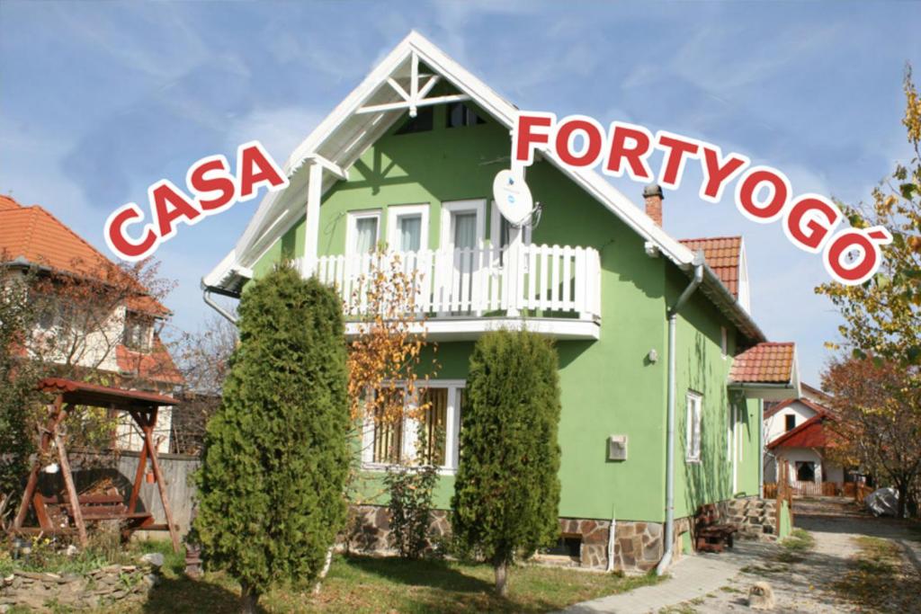 una casa con un signo de palabra en su lado en Casa Fortyogo, en Tîrgu Secuiesc