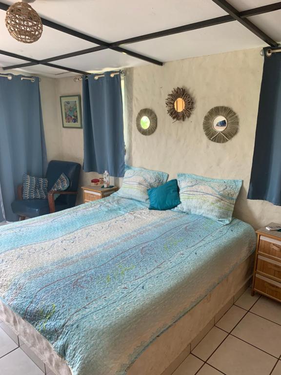 a large bed in a bedroom with blue curtains at Shalpa surf villa in La Libertad