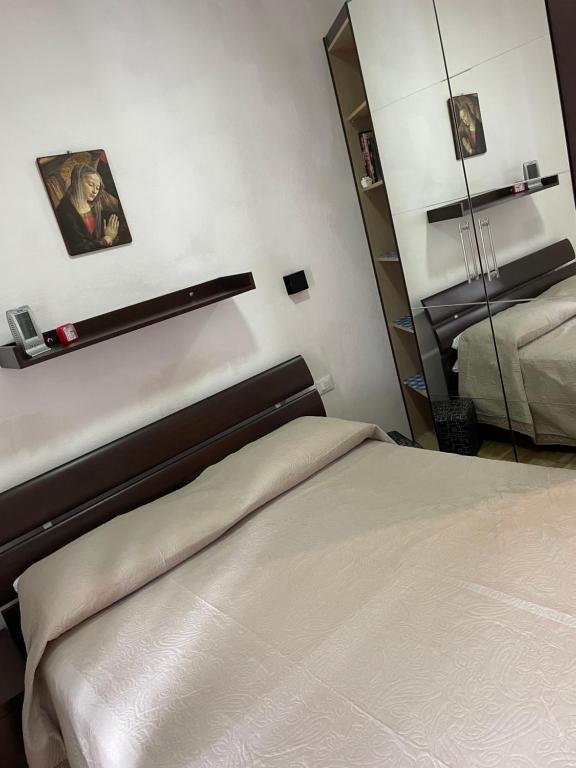 um quarto com uma cama e um espelho na parede em Appartamento Edelweiss em Fiera di Primiero