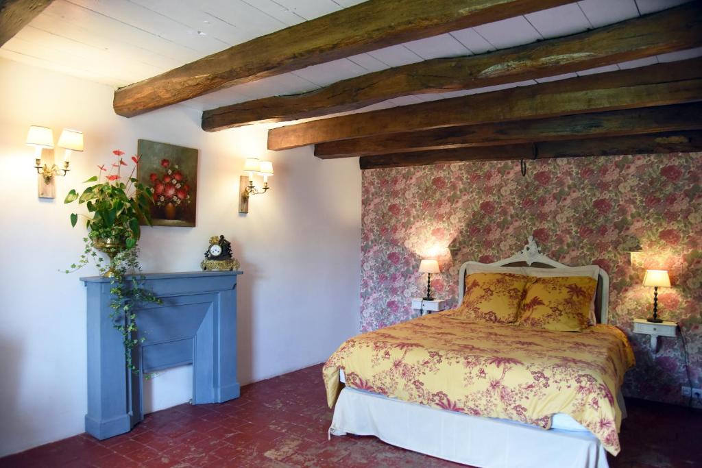um quarto com uma cama com uma parede floral em Au cœur de Fontaine em Fontaine-Française