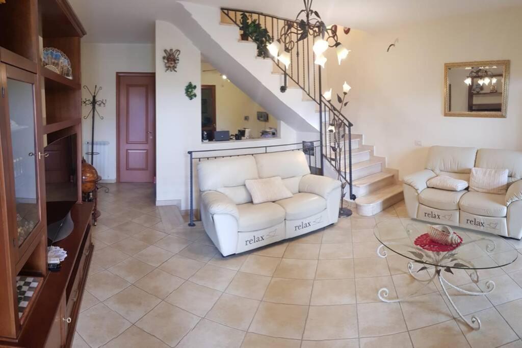 ein Wohnzimmer mit 2 weißen Sofas und einer Treppe in der Unterkunft CASA dolce CASA in Valmontone