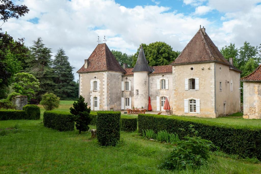 an old castle with two towers on a green field at Chateau La Rochette in Lisle