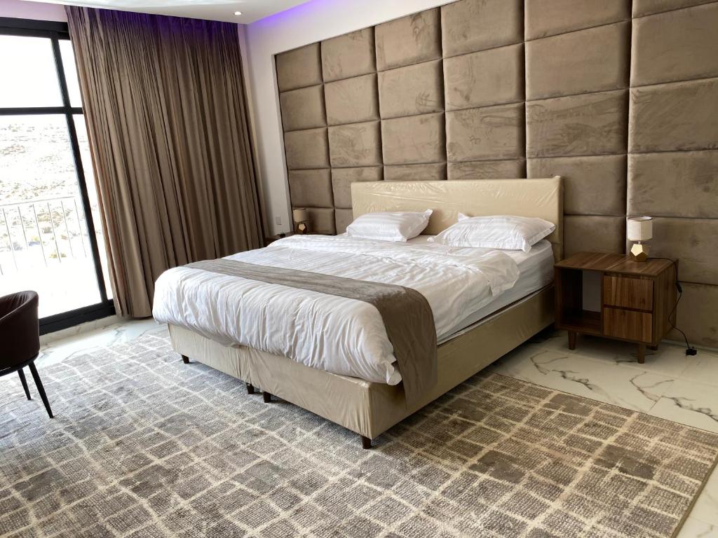 a bedroom with a large bed and a large window at شاليه كاردڤ1 in Al Baha