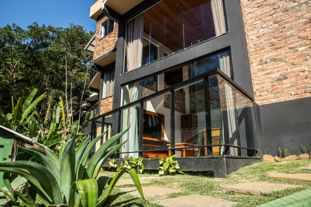 a house with large glass windows and a plant at ATLANTIC FOREST HOUSE AT FOREST in Angra dos Reis