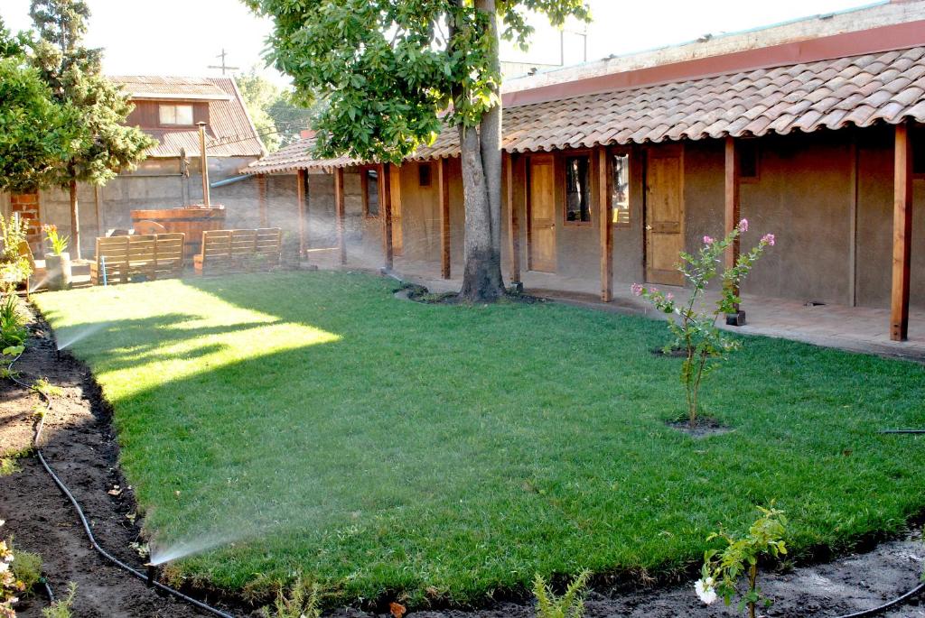 a yard in front of a house with a tree at Hotel Boutique Casona Violeta in San Carlos