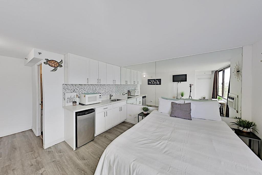 um quarto branco com uma cama grande e uma cozinha em Hawaiian Monarch 2312 condo em Honolulu