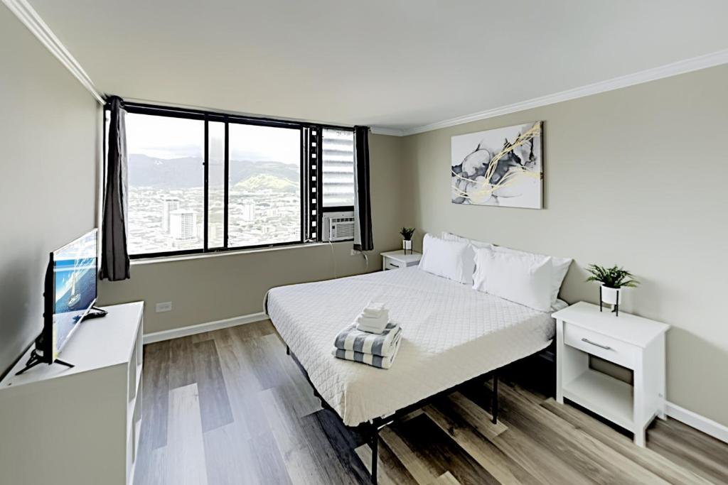 a white bedroom with a bed and a desk at Hawaiian Monarch 3707B condo in Honolulu