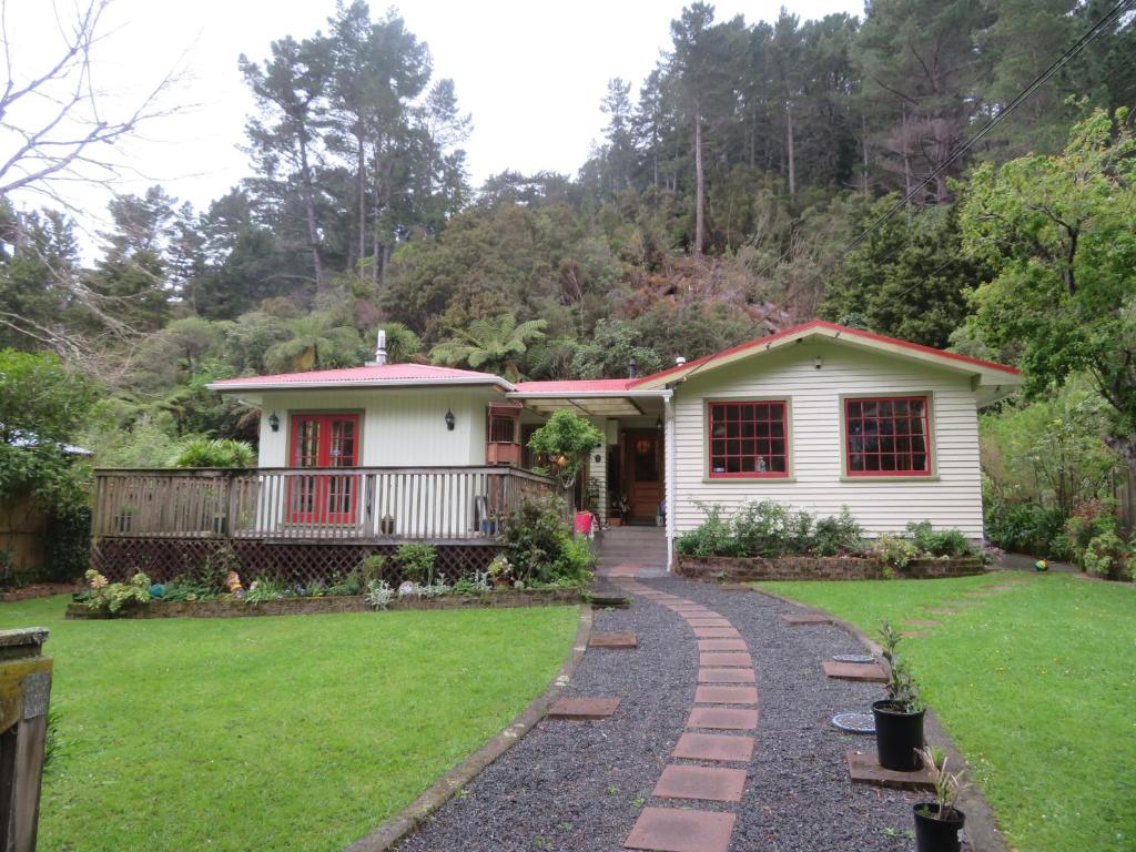 a house with a garden and a walkway at Twin Totara Cottage in Upper Hutt