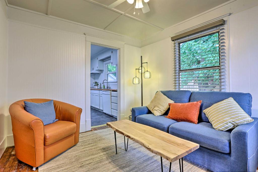 sala de estar con sofá azul y silla en Pet-Friendly Baker City Escape with Private Yard! en Baker City