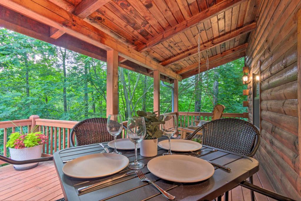 a dining table on the deck of a cabin at 7 Mi to Ski Slopes Mars Hill Cabin with Hot Tub! in Mars Hill