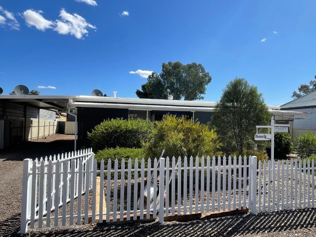 a white picket fence in front of a house at Homely Cottage in Hawker