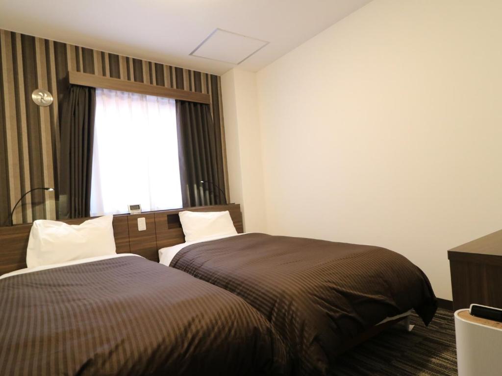 Postel nebo postele na pokoji v ubytování Odawara Terminal Hotel