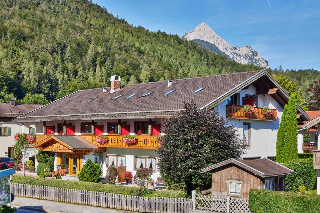 a large house with a fence in front of a mountain at Hotel Franziska in Mittenwald