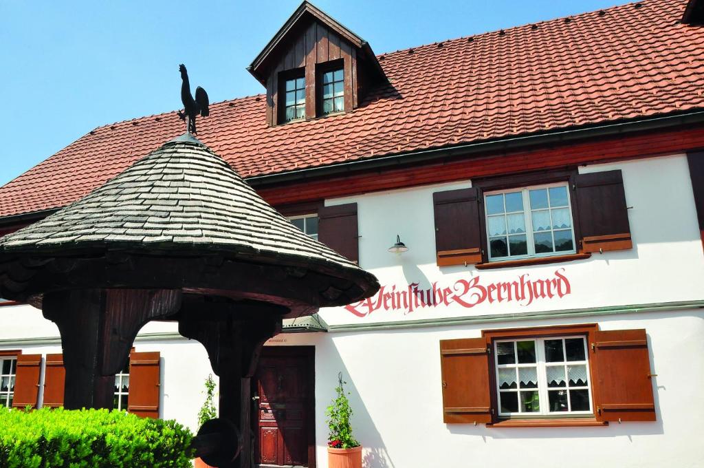un edificio con una sombrilla grande delante de él en Gästehaus Bernhard, en Lochau