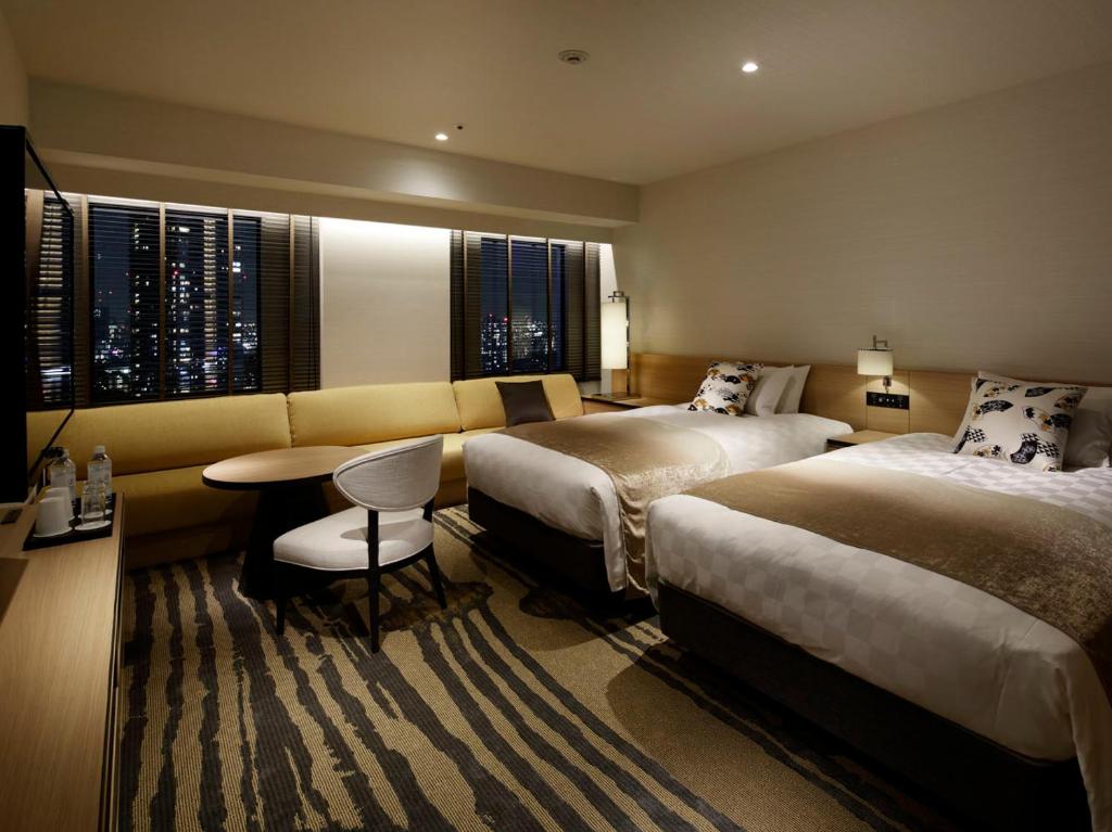Habitación de hotel con 2 camas y sofá en Sunshine City Prince Hotel Ikebukuro, en Tokio
