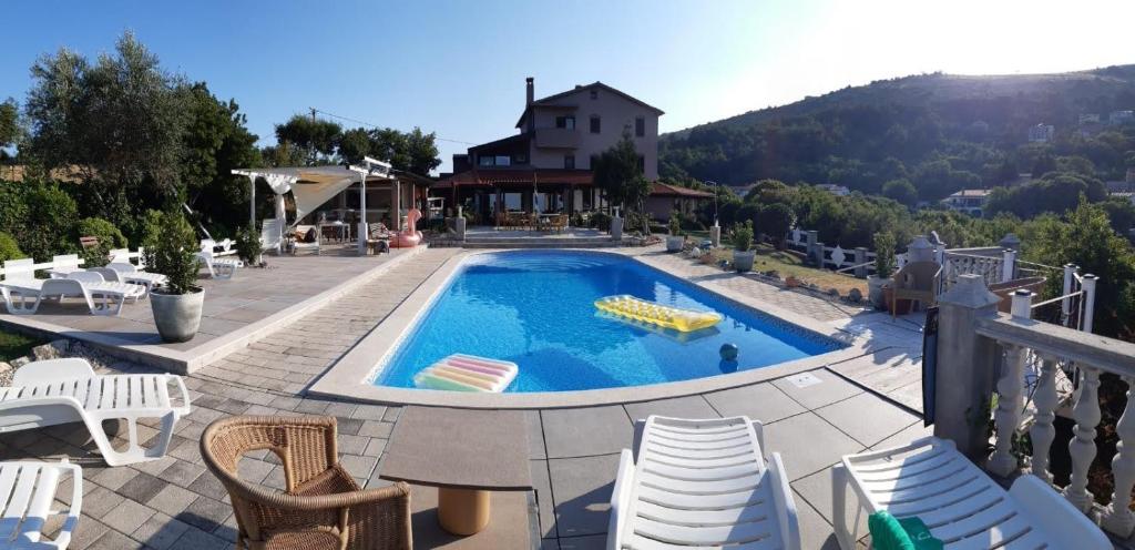 basen na patio z krzesłami i dom w obiekcie Casa Perla Holidays w mieście Juraši