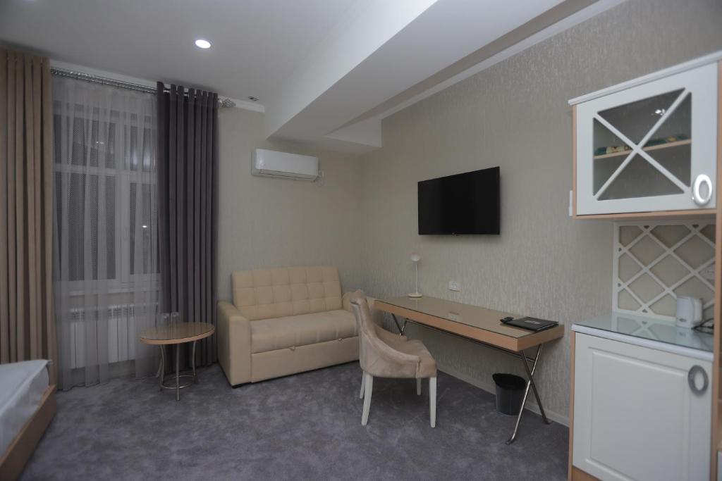 a hotel room with a couch and a table and a desk at Reikartz Amirun Tashkent in Tashkent