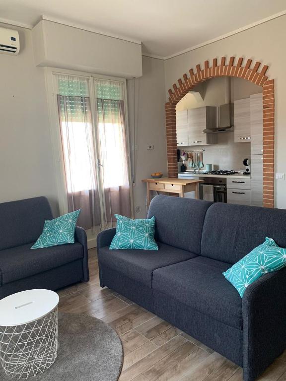 sala de estar con sofá azul y cocina en Casina Summer en Tirrenia