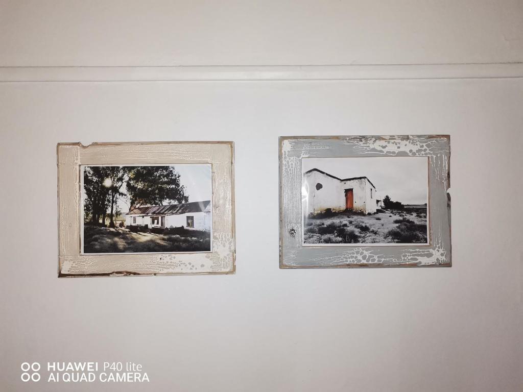 deux images encadrées d'une maison sur un mur dans l'établissement Bird Haven Guesthouse, à Leribe