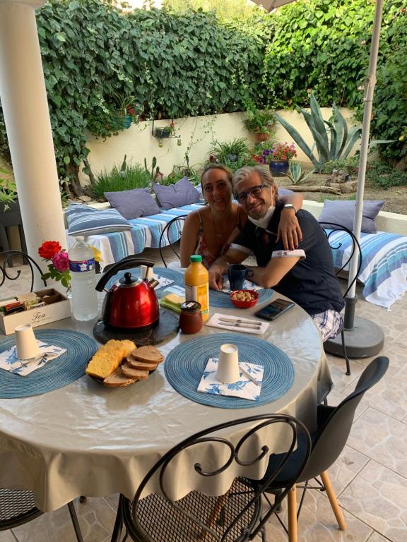 deux hommes assis à une table avec de la nourriture dans l'établissement Villa Croix d Argent 15mn des plages, à Montpellier