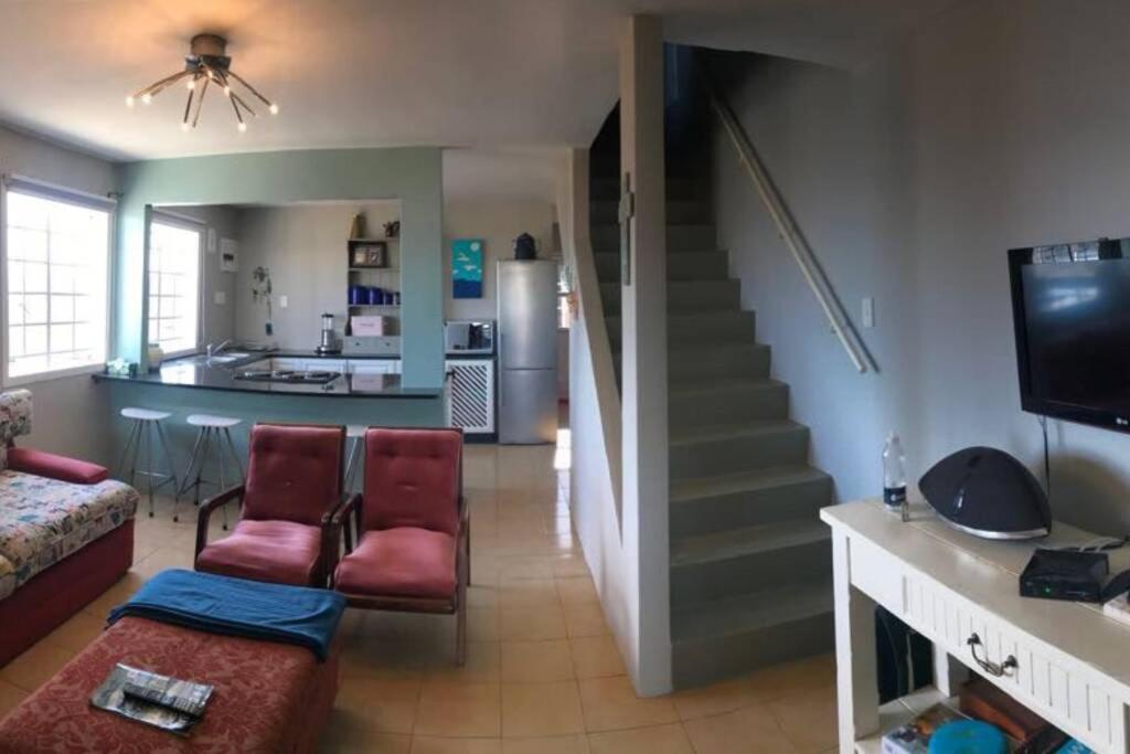 a living room with a staircase and a kitchen at Newlands East, Durban Home, Panoramic•Peaceful• in Duffʼs Road