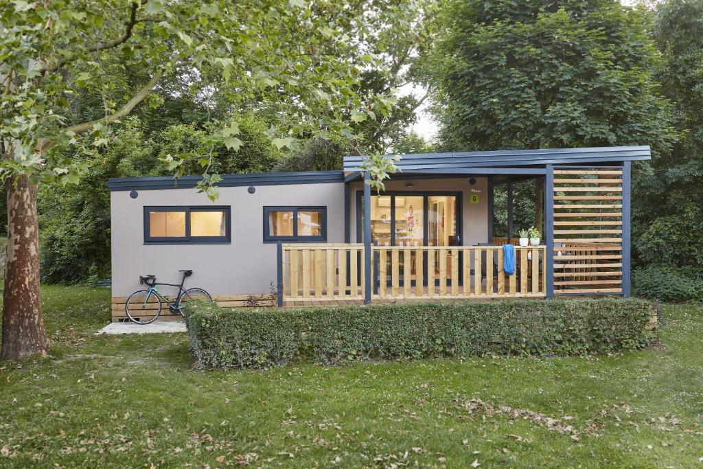 a tiny house in a yard with a tree at Donaupark Camping Tulln in Tulln
