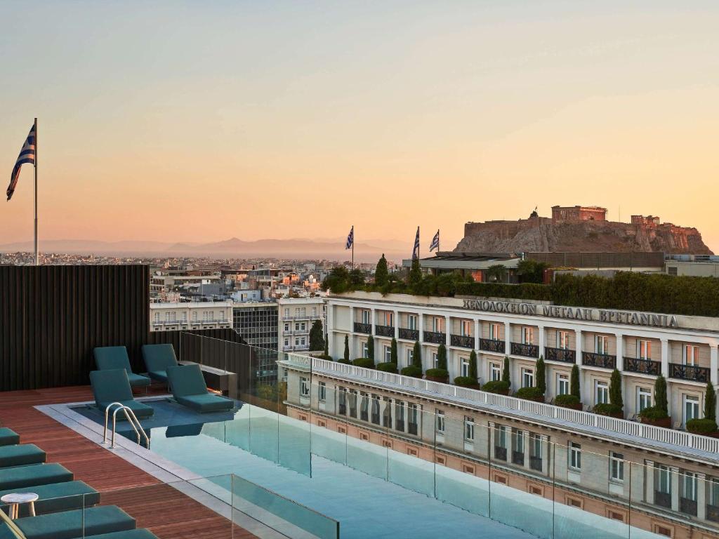 a hotel rooftop with a view of the city at Athens Capital Center Hotel - MGallery Collection in Athens