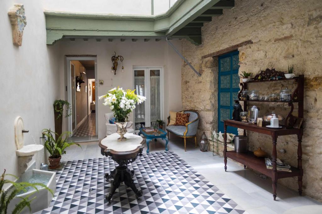 - un salon avec une table et une chaise dans l'établissement Casa Portus Gaditanus s XVIII Patio Andaluz, à El Puerto de Santa María