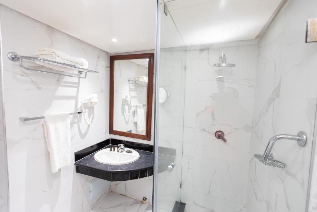 a bathroom with a sink and a shower at Hotel Majestic in Casablanca