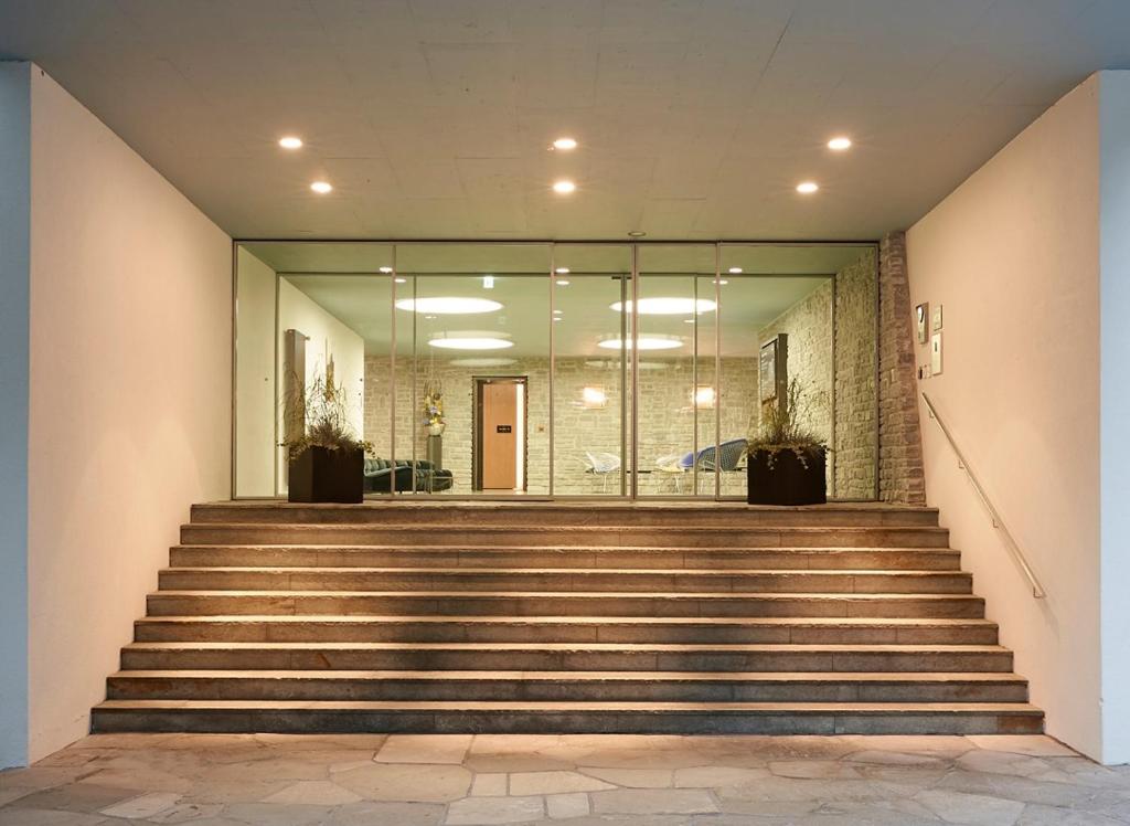 a set of stairs in a building with glass doors at House of Architects in Vals