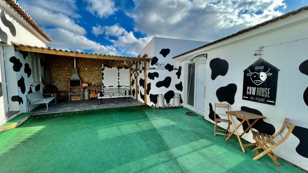 una casa con un pavimento verde e un murale di mucca di Azores Cow House a Calhetas