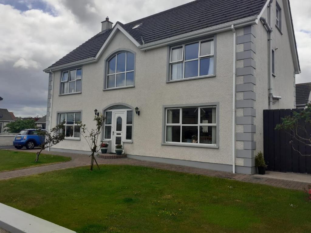 a house with a blue car parked in front of it at Mussenden House in Articlave
